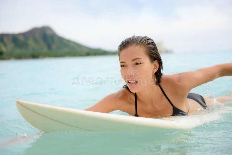 Surfingu surfingowa dziewczyny paddle dla kipieli na surfboard zdjęcie stock Surfingu surfingowa dziewczyny paddle dla kipieli na surfboard zdjęcie stock