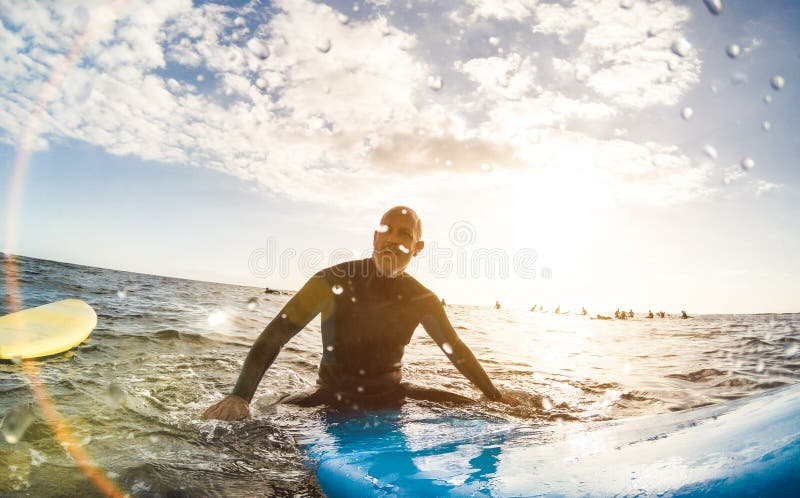 Surfista do indivíduo que relaxa na prancha no por do sol em Tenerife imagens de stock royalty free Surfista do indivíduo que relaxa na prancha no por do sol em Tenerife imagens de stock royalty free