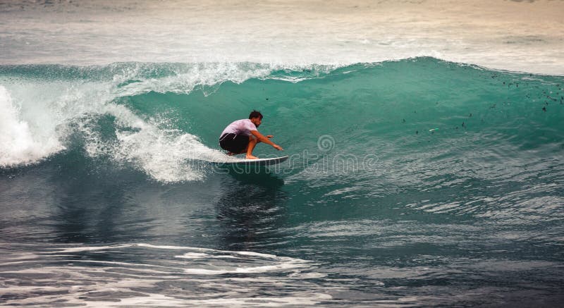 Surfista sull'oceano Wave blu, Bali, Indonesia Guidando in tubo fotografie stock Surfista sull'oceano Wave blu, Bali, Indonesia Guidando in tubo fotografie stock