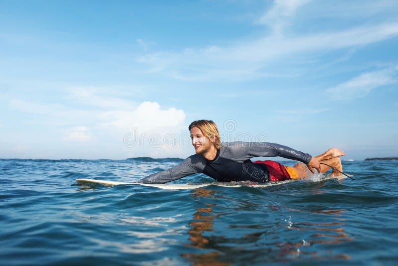 Surfista. un hombre de surf sonriente en un retrato de surf. un tipo guapo en traje de baño nadando en el océano. fotos de archivo libres de regalías