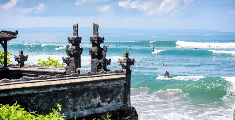 Surfistas em uma onda por um templo em bali 3 foto de stock Surfistas em uma onda por um templo em bali 3 foto de stock