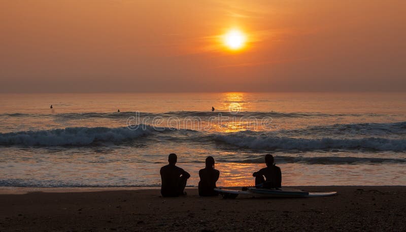 Surfisti che ammirano tramonto