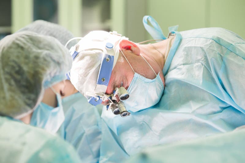 Surgeon and his assistant during cosmetic sugery in hospital ope