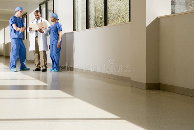 Surgeons and doctor looking at file stock photo Surgeons and doctor looking at file stock photo