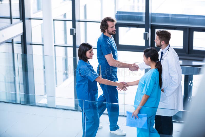 Surgeons, doctor and nurse shaking hands with each other royalty free stock photo Surgeons, doctor and nurse shaking hands with each other royalty free stock photo