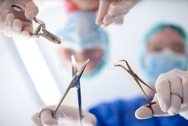 Surgeons Holding Medical Instruments in Hands and Looking at Pat Stock