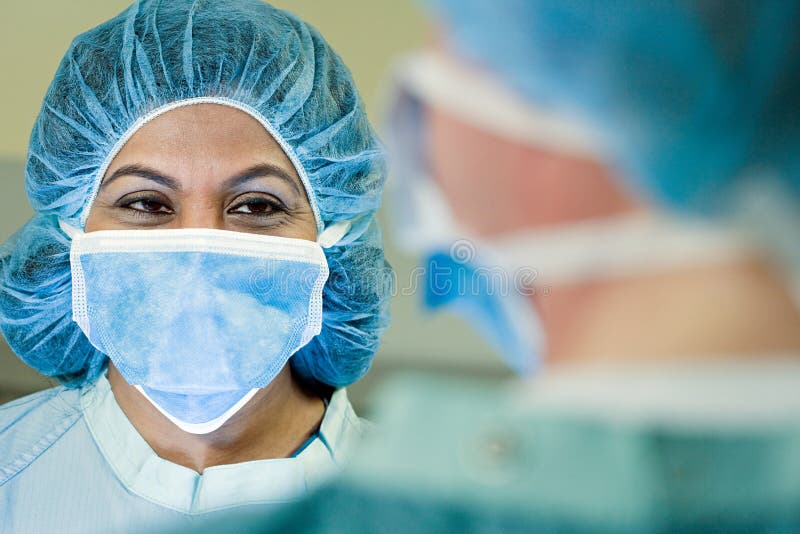 Portrait of Two Surgeons Wearing Surgical Masks in the Operating Room, Looking at Camera Stock