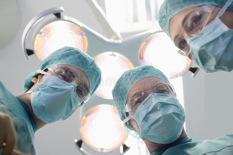 Surgeons Under Surgery Lights In Operating Theatre stock images