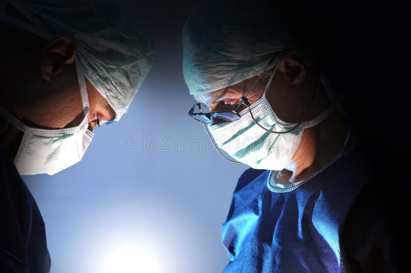Medici squadra in chirurgia in uno sfondo scuro.