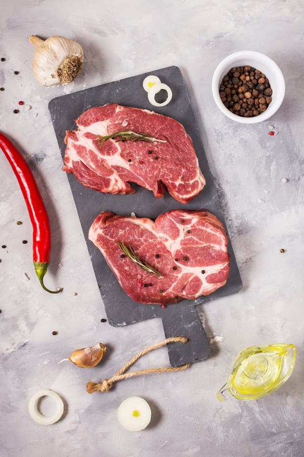 Surowego mięsa stek z seasonings na betonowym tle Stek przygotowywający dla gotować Grilla pojęcie Składniki dla mięsnego prażaka fotografia royalty free Surowego mięsa stek z seasonings na betonowym tle Stek przygotowywający dla gotować Grilla pojęcie Składniki dla mięsnego prażaka fotografia royalty free