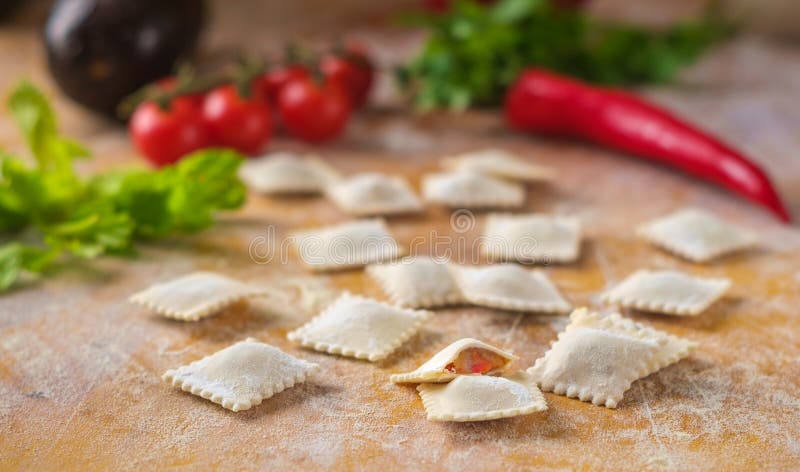 Surowy barwiony pierożka pierożek w mące z warzywami i pomidorami obrazy stock Surowy barwiony pierożka pierożek w mące z warzywami i pomidorami obrazy stock