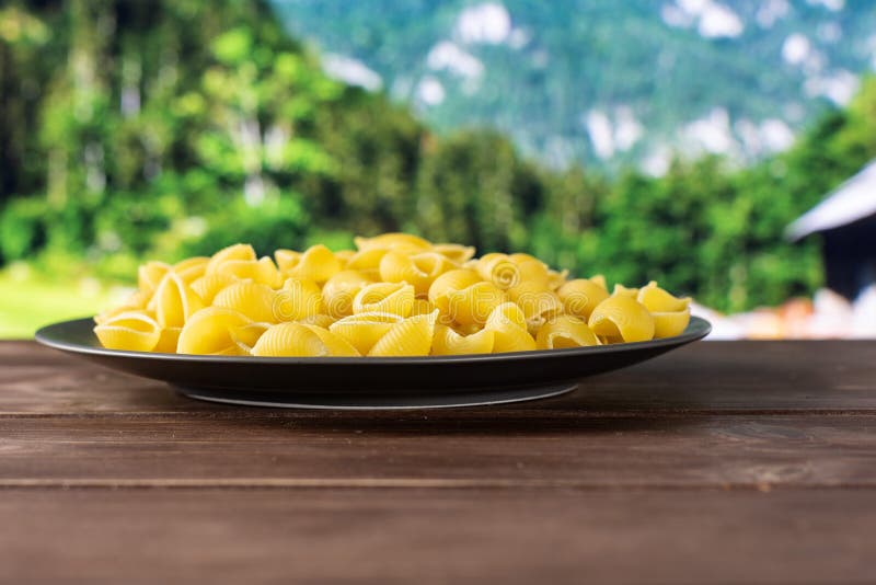 Surowy żółty makaronu conchiglie z kraj naturą zdjęcia royalty free Surowy żółty makaronu conchiglie z kraj naturą zdjęcia royalty free