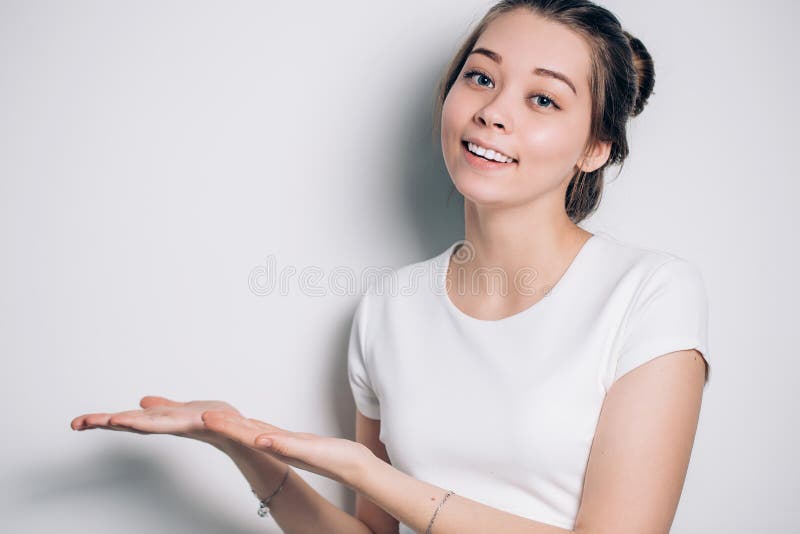 Surpresa da mulher que mostra em sentidos diferentes em você o produto imagem de stock royalty free Surpresa da mulher que mostra em sentidos diferentes em você o produto imagem de stock royalty free