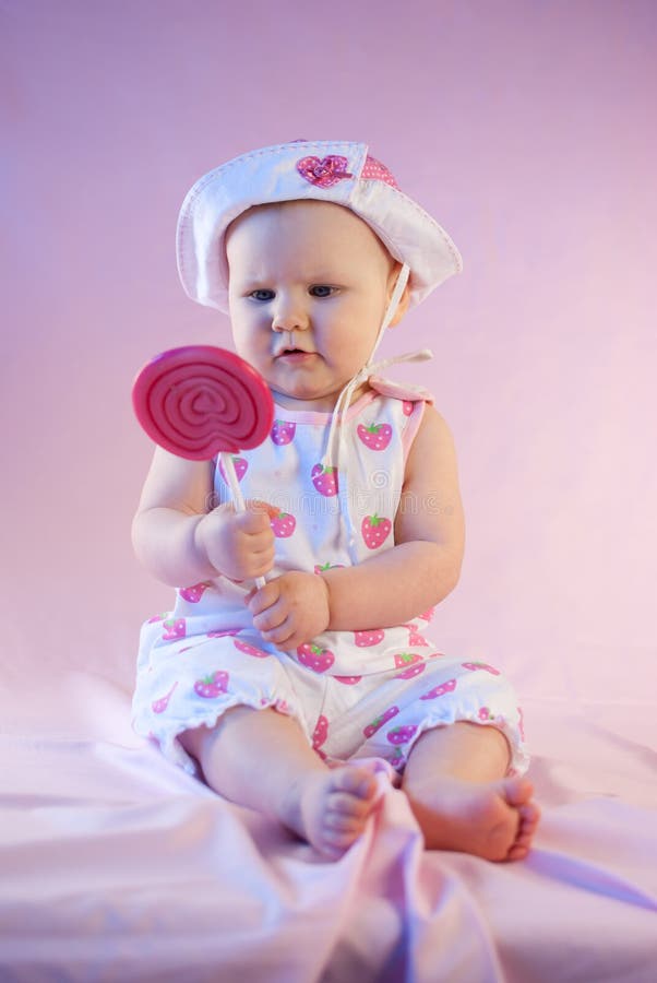 Girl with a Lollipop in Her Hand and Pink Dress Stock Photo - Image of ...