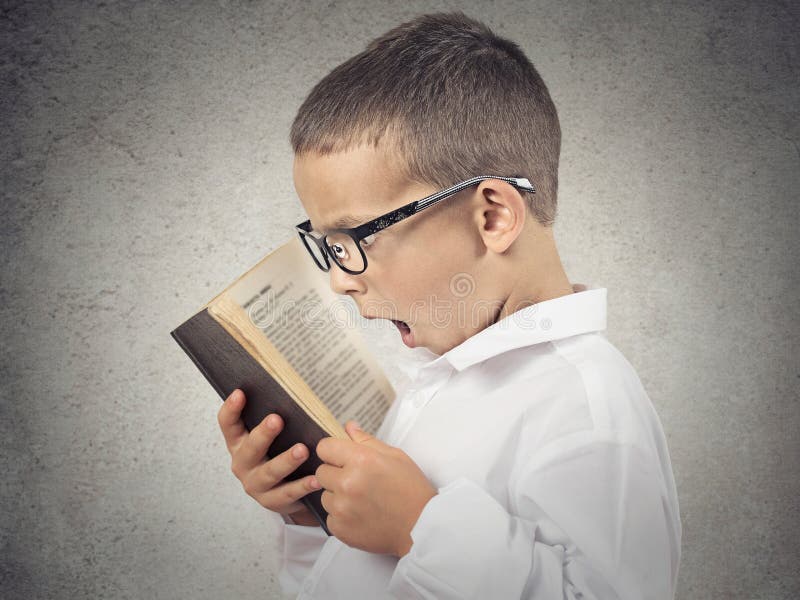 Surprised boy, little man reading book royalty free stock photography