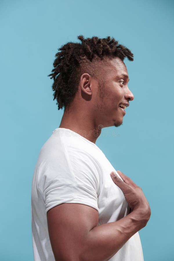 The surprised business Afro-American man standing and looking blue background. Profile view.