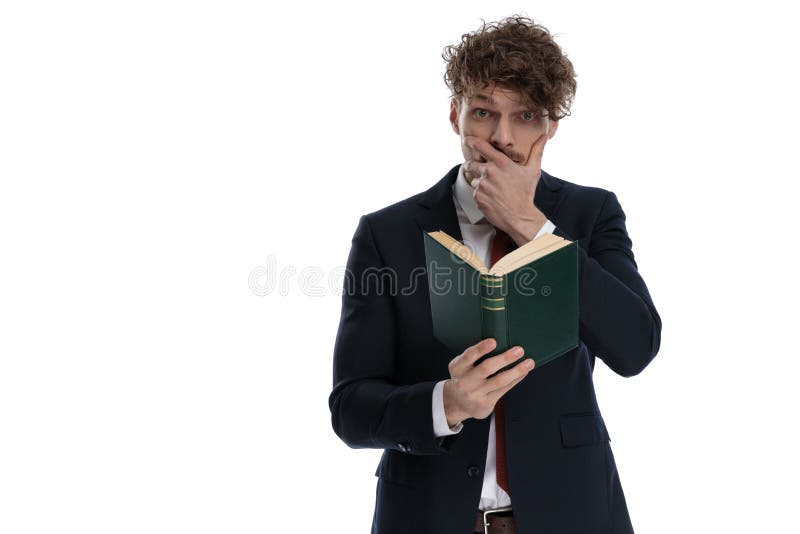 Surprised businessman reading book and covering his mouth royalty free stock image
