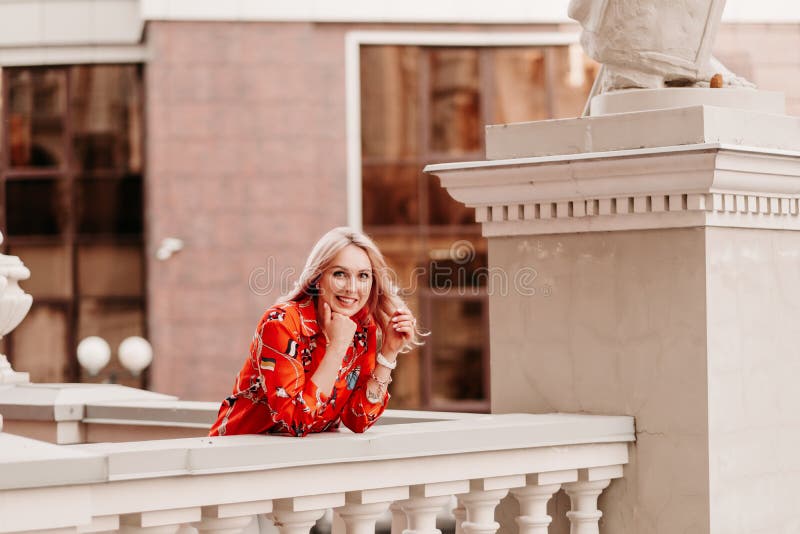 Smiling blonde girl with curly hair waving from a balcony - wide 10