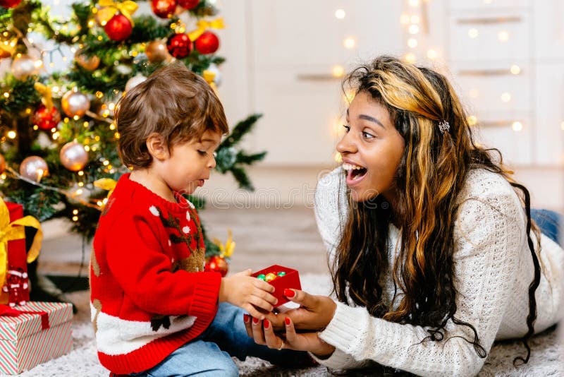 The Surprised Kid and His Mom with a Big Smile Next To the Christmas