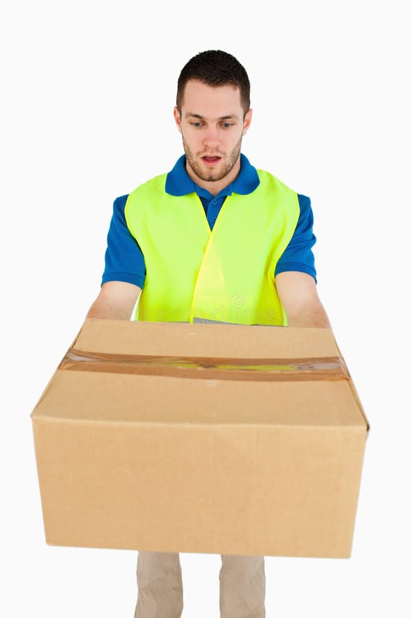 Surprised looking delivery man handing over parcel royalty free stock image