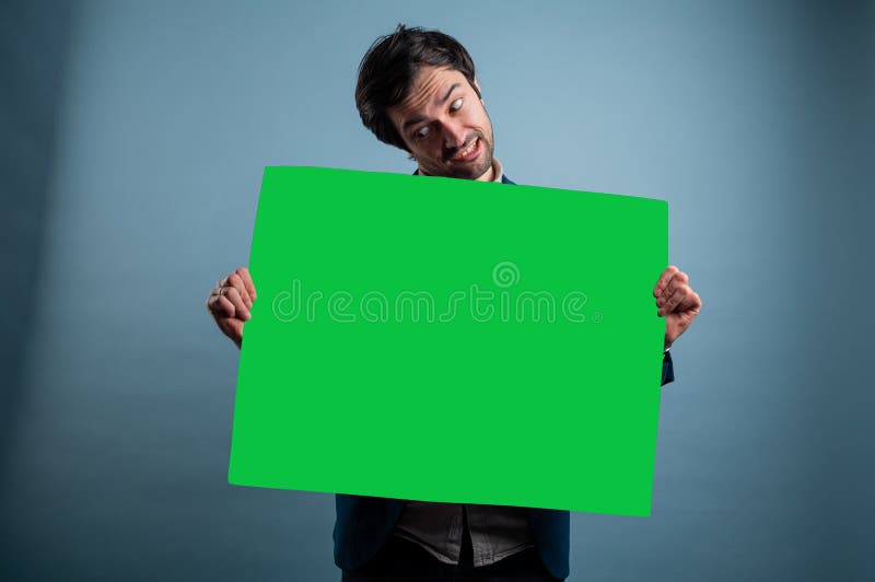 Surprised man holding green advertising banner stock photo