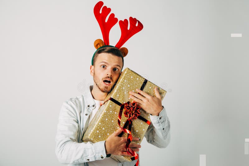 Surprised man in red christmas hat over grey background. Holiday, celebration.