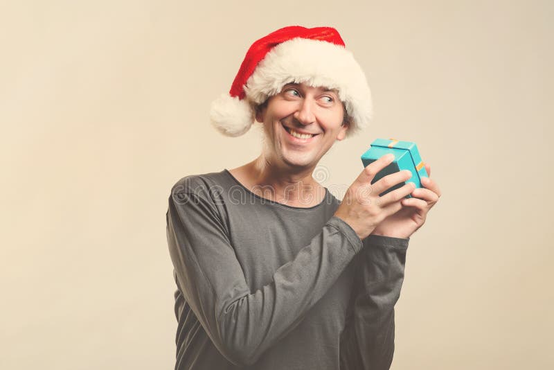 Surprised man in Santa hat holding gift box. Santa christmas man isolated on white, copy space. Christmas holidays. Happy man stock images Surprised man in Santa hat holding gift box. Santa christmas man isolated on white, copy space. Christmas holidays. Happy man stock images