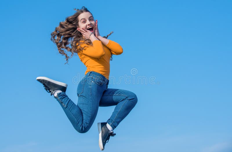 surprised teen girl jump high on sky background