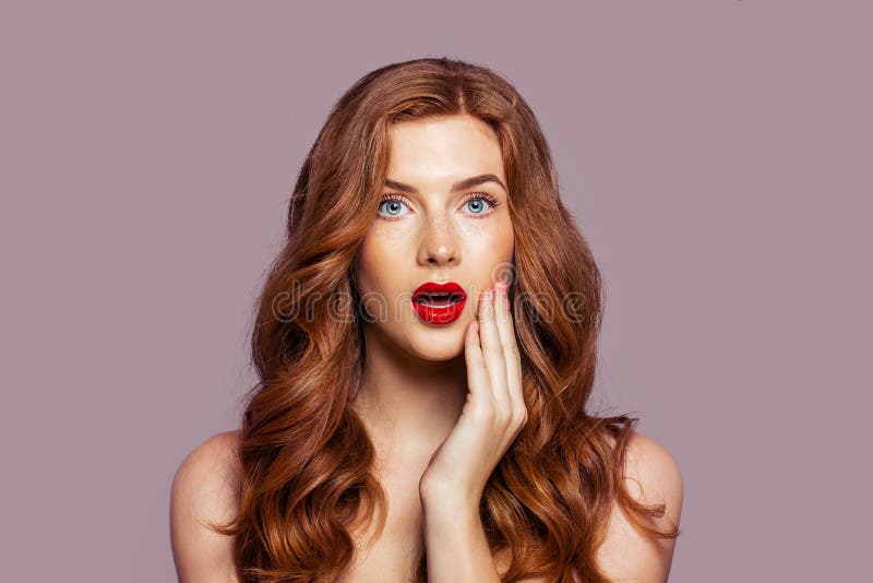 Surprised woman with beautiful red hair on bright pink background. Redhead girl with opened mouth portrait royalty free stock image Surprised woman with beautiful red hair on bright pink background. Redhead girl with opened mouth portrait royalty free stock image