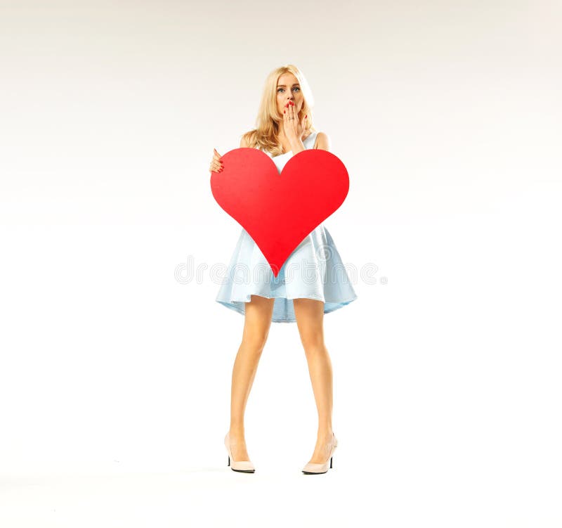 Surprised woman holding a big heart