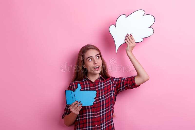 A surprised girl holding a image of a thought or an idea and a thumbs up sign and looking away. stock photography A surprised girl holding a image of a thought or an idea and a thumbs up sign and looking away. stock photography