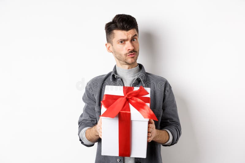 Surprised Young Man Look with Disbelief and Hold Surprise Gift, Raising ...