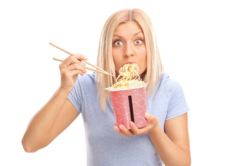 Surprised young woman eating Chinese noodles