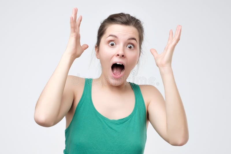 Surprised young woman in green clothes shouting shocked with great news stock photos Surprised young woman in green clothes shouting shocked with great news stock photos