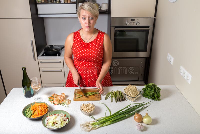 Download Surprised Girl In Kitchen Cutting Asparagus Stock Photo - Image of camera, adult: 100980996