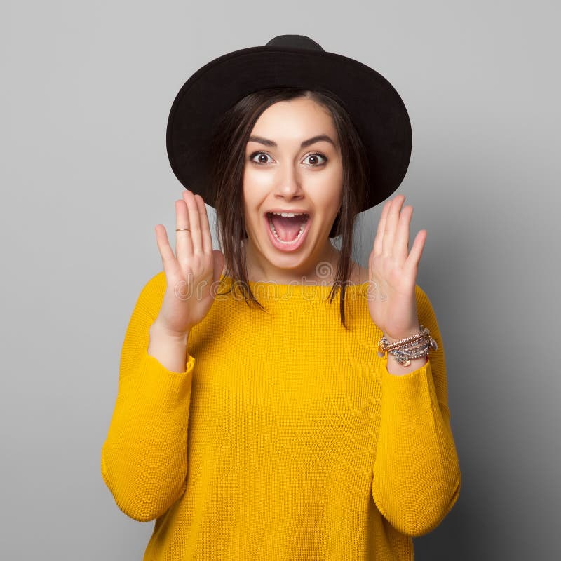 Surprised young woman over gray background.