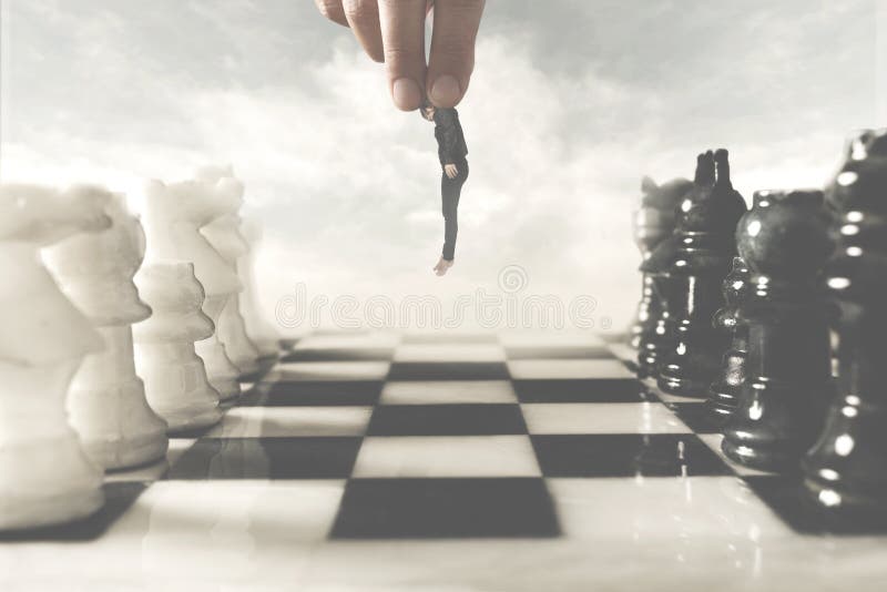 Surreal photo of a hand moving a human pawn on a chessboard, concept of power and control in business. Surreal photo of a hand moving a human pawn on a chessboard, concept of power and control in business