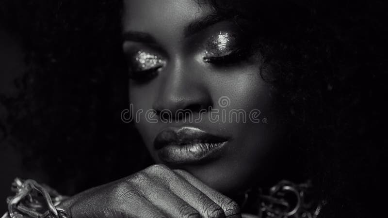 Surreales Schwarzweiss-Nahaufnahmeporträt des weiblichen Modells des jungen Afroamerikaners mit Goldglattem Make-up Gesicht Art stockfotografie Surreales Schwarzweiss-Nahaufnahmeporträt des weiblichen Modells des jungen Afroamerikaners mit Goldglattem Make-up Gesicht Art stockfotografie