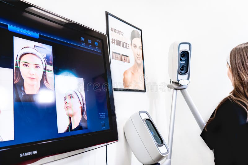 Surrey, BC / Canada - 07/16/19: Patient sitting for Vectra 3D imaging scan, in a beauty clinic, for tracking procedure results with digital analysis. Surrey, BC / Canada - 07/16/19: Patient sitting for Vectra 3D imaging scan, in a beauty clinic, for tracking procedure results with digital analysis