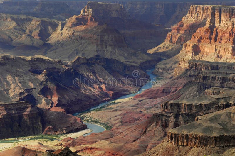 Surrounding the Colorado River, the Grand Canyon takes on an orange hue under the setting sun. royalty free stock image