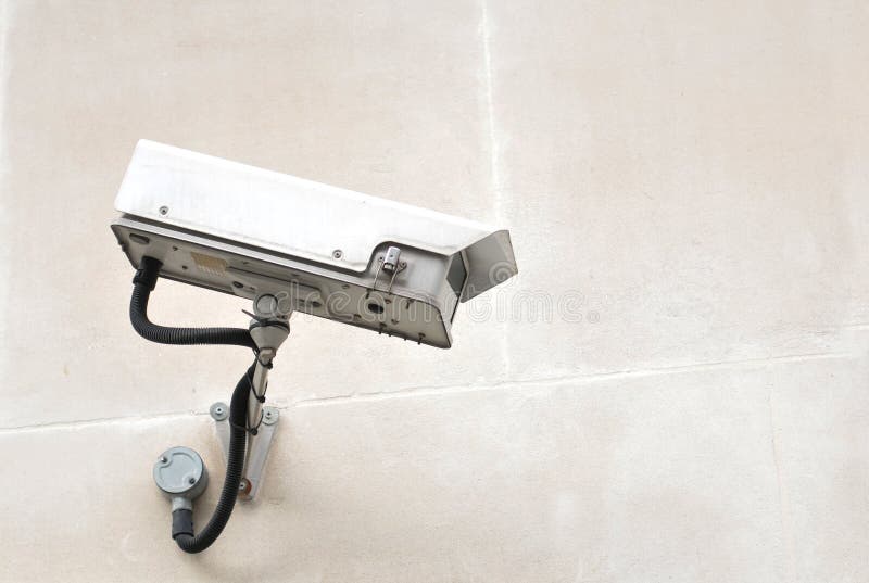 Wired Surveillance Camera Mounted on a Brick Wall. White Wire Anti