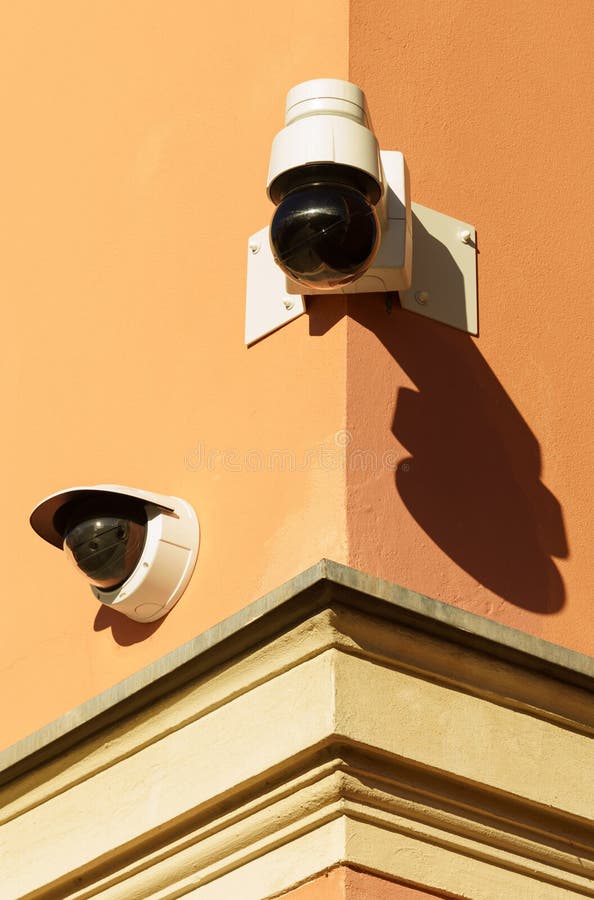 Surveillance Cameras are Installed on the Orange Wall of the Building