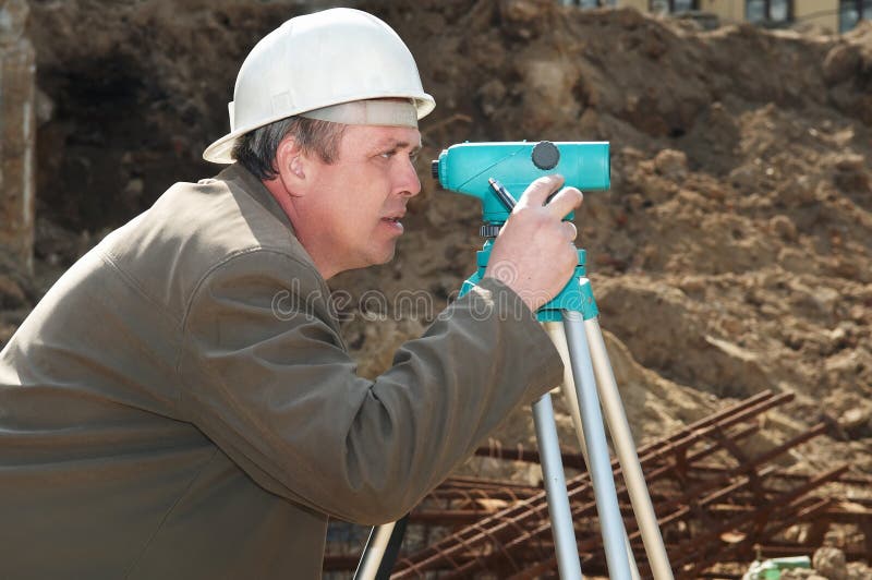 Worker surveyor measuring distances, elevations and directions on construction site by theodolite level transit equipment. Worker surveyor measuring distances, elevations and directions on construction site by theodolite level transit equipment