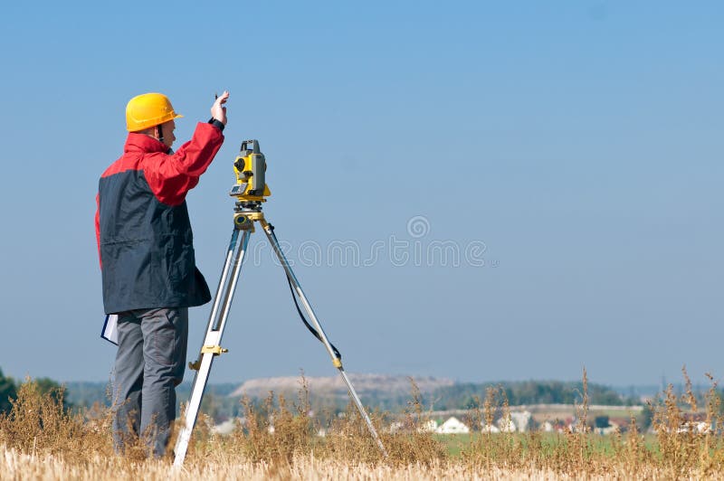 Surveyor worker making measurement in a field with theodolite total station equipment. Surveyor worker making measurement in a field with theodolite total station equipment