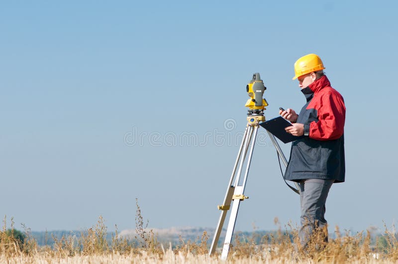 Surveyor worker making measurement in a field with theodolite total station equipment. Surveyor worker making measurement in a field with theodolite total station equipment