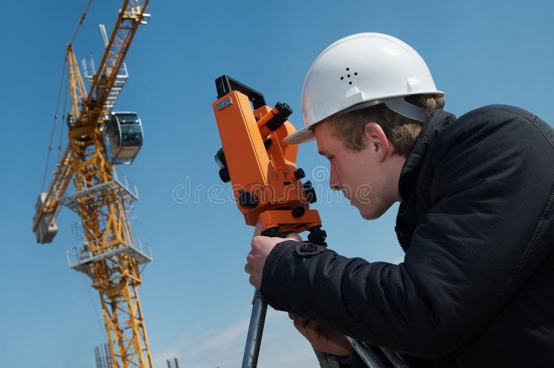 Worker surveyor measuring distances, elevations and directions on construction site by theodolite level transit equipment. Worker surveyor measuring distances, elevations and directions on construction site by theodolite level transit equipment