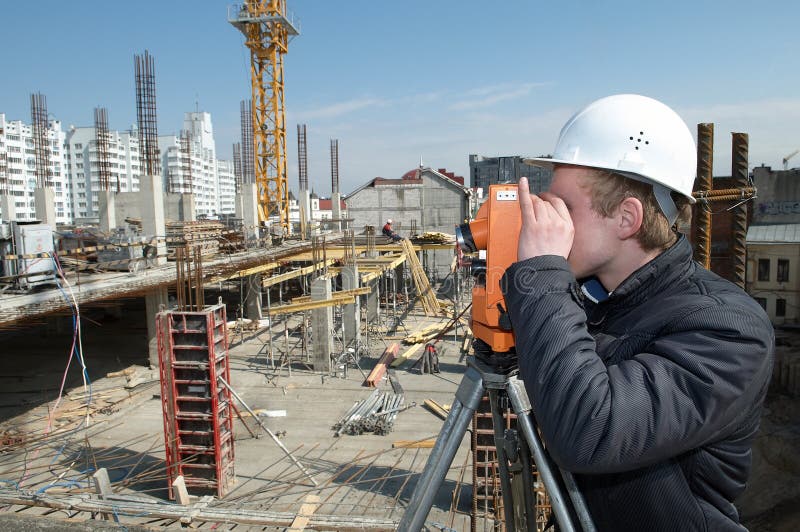 Worker surveyor measuring distances, elevations and directions on construction site by theodolite level transit equipment. Worker surveyor measuring distances, elevations and directions on construction site by theodolite level transit equipment