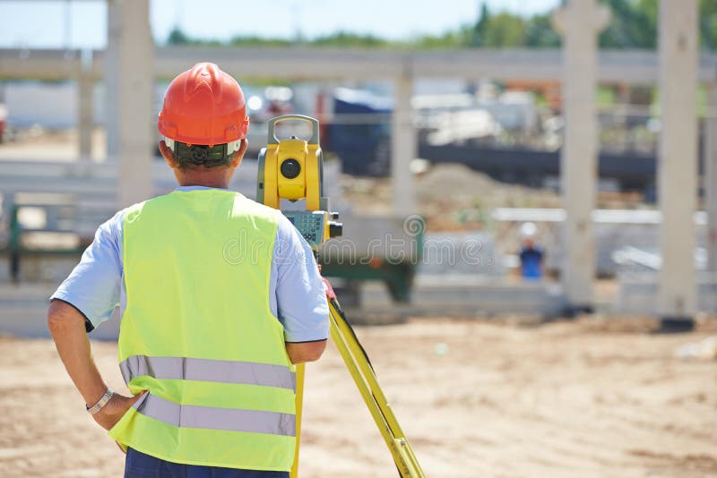 Portrait of builder worker with theodolite transit equipment at construction site outdoors during surveyor work. Portrait of builder worker with theodolite transit equipment at construction site outdoors during surveyor work