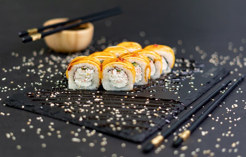 Sushi Roll with Cream Cheese and Fried Salmon on Dark Background Stock