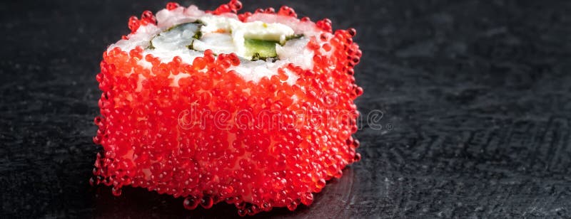 Sushi roll of fresh shrimps cucumber avocado red Tobiko caviar and Philadelphia. Cheese Asian food on dark background macro with copy space close-up royalty free stock photo Sushi roll of fresh shrimps cucumber avocado red Tobiko caviar and Philadelphia. Cheese Asian food on dark background macro with copy space close-up royalty free stock photo